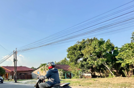 Seorang warga melintas di Kota Jambi pada siang terik, Selasa (23/9/2026). (Dok. Stepanus)