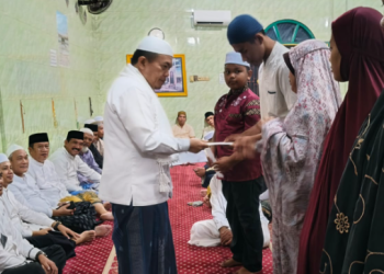 Gubernur Jambi Al Haris menyerahkan santunan kepada anak yatim dan dhuafa usai Safari Subuh di Masjid Darussa’adah, Desa Pondok Meja, Kecamatan Mestong, Muaro Jambi, Jumat (26/9/2025). (Dok. Stepanus)