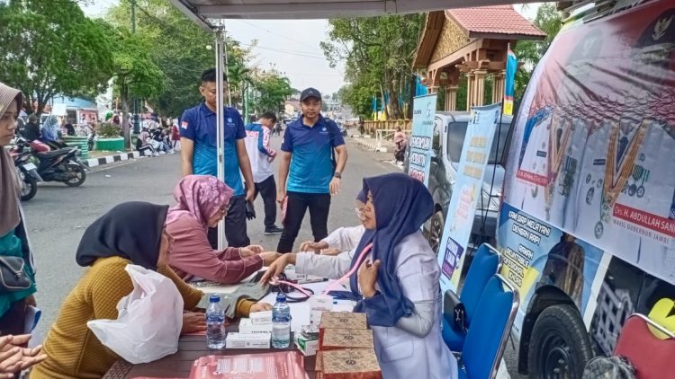 Petugas Jasa Raharja Muara Bungo melakukan pemeriksaan kesehatan gratis bagi masyarakat dalam program Mobile Unit Keselamatan Lalu Lintas (MUKL) yang digelar di area Car Free Day, Muara Bungo, Agustus 2025. (Dok. Humas JR)