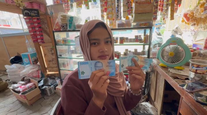 Seorang pedagang di Kota Jambi memperlihatkan uang palsu pecahan Rp50.000 dan Rp100.000 yang diterimanya saat bertransaksi di toko kelontong, Kamis (18/9/2025). (Dok. Nahar)