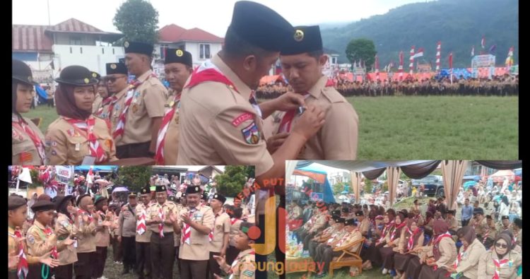Bupati Kerinci Monadi menyematkan tanda peserta kepada anggota Pramuka saat membuka Jambore Kwarran Siulak dan Siulak Mukai di Lapangan TriDes Tebing Tinggi, Sabtu (20/9/2025). (Dok. Deko)