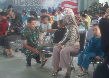 Seorang prajurit TNI berbincang dengan warga saat pelaksanaan bakti kesehatan dalam rangka HUT ke-80 TNI di Lapangan Tenis Indoor Korem 042/Gapu, Jambi, Minggu (21/9/2025). (Dok. Nahar)