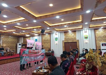 Empat mahasiswa membentangkan spanduk dan poster berisi tuntutan masyarakat terkait jalan rusak, pendidikan, dan kesehatan saat pelantikan Kapema Tanjung Jabung Timur di Balai Pertemuan Daerah, Minggu (21/9/2025). (Dok. Daus)