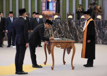 Deputi Gubernur Bank Indonesia Juda Agung menandatangani berita acara pelantikan sebagai Anggota Dewan Komisioner OJK Ex-officio BI, disaksikan Ketua Mahkamah Agung RI Sunarto di Gedung MA Jakarta, Selasa (23/9/2025). (Dopk. Humas OJK Jambi)