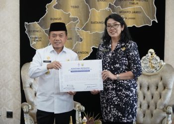 Gubernur Jambi Al Haris bersama Kepala Kanreg VII BKN Palembang Heni Sri Wahyuni menunjukkan nota kesepahaman penguatan sistem merit dan manajemen talenta ASN usai penandatanganan di Rumah Dinas Gubernur Jambi, Rabu (24/9/2025). (Dok. Daus)