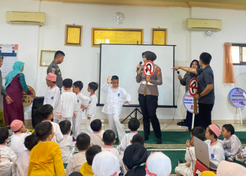 Personel Satlantas Polresta Jambi memperkenalkan rambu lalu lintas kepada anak-anak TK Al-Mutmainnah dalam kegiatan Polisi Sahabat Anak, Jumat (26/9/2025). (Dok. Nahar)