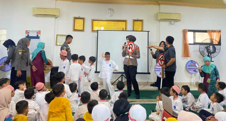 Personel Satlantas Polresta Jambi memperkenalkan rambu lalu lintas kepada anak-anak TK Al-Mutmainnah dalam kegiatan Polisi Sahabat Anak, Jumat (26/9/2025). (Dok. Nahar)