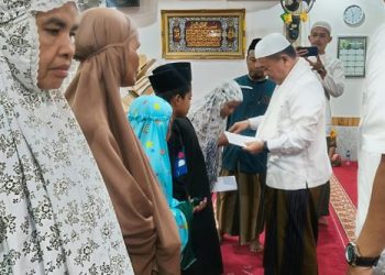Gubernur Jambi Al Haris menyerahkan santunan kepada anak yatim dan kaum dhuafa usai melaksanakan salat Subuh berjamaah di Masjid Miftahul Huda, Kelurahan Bagan Pete, Kecamatan Alam Barajo, Kota Jambi, Jumat (17/10/2025). (Dok. Daus)