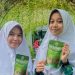 Dua siswi MAN 2 Kota Jambi, Aurellia Yasmin Nizara (kanan) dan Nyimas Syakirah Nadine (kiri), memperlihatkan produk inovatif biskuit sehat berbasis daun kelor dan umbi gadung. (Dok. Sinsen)