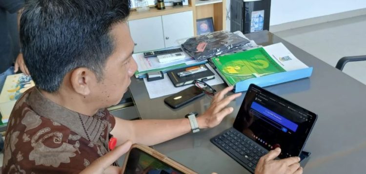 Kepala Dinas Komunikasi dan Informatika Kota Jambi, Saleh Ridha, menunjukkan tampilan Aplikasi SIPOLAR yang digunakan untuk memantau distribusi solar bersubsidi di Kota Jambi, Jumat (24/10/2025). (Dok. Daus)