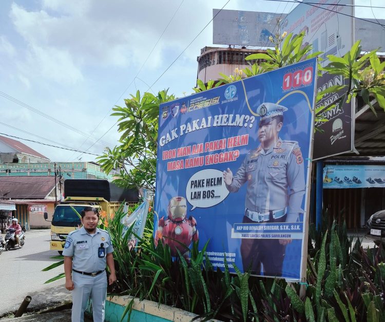 Anggota Satlantas Polres Sarolangun bersama Jasa Raharja memasang spanduk imbauan keselamatan berlalu lintas di titik rawan kecelakaan, Rabu (1/10/2025). (Dok, Humas)
