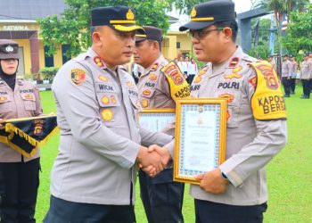 Kapolres Tanjung Jabung Timur AKBP M. Kuswicaksono, S.I.K., M.H. menyerahkan piagam penghargaan kepada Kapolsek Berbak IPDA Hansmadi Simangunsong pada upacara di lapangan Polres Tanjab Timur, Senin (6/10/2025). (Dok. Humas)
