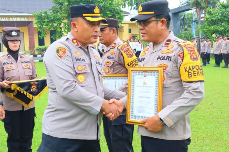 Kapolres Tanjung Jabung Timur AKBP M. Kuswicaksono, S.I.K., M.H. menyerahkan piagam penghargaan kepada Kapolsek Berbak IPDA Hansmadi Simangunsong pada upacara di lapangan Polres Tanjab Timur, Senin (6/10/2025). (Dok. Humas)