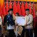 Wakil Gubernur Jambi Abdullah Sani menyerahkan piagam penghargaan kepada penerima Muzakki Konsisten dalam Rakorda BAZNAS Provinsi Jambi Tahun 2025 di Auditorium Rumah Dinas Gubernur Jambi, Senin (13/10/2025) (Dok. Erit - Kominfo)