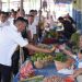 Bupati Kerinci Monadi menyerahkan hasil pertanian kepada warga saat meninjau Pasar Harian Desa Pasar Senen, Kecamatan Siulak, Rabu (15/10/2025). (Dok. Deko)