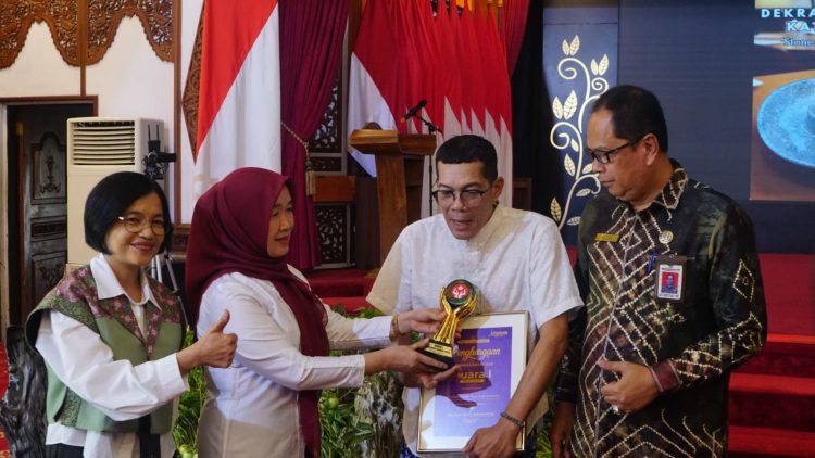 Ketua Dekranasda Provinsi Jambi Hj. Hesti Haris menyerahkan penghargaan kepada pelaku usaha kreatif berprestasi pada acara Temu Perajin Provinsi Jambi Tahun 2025 di Auditorium Rumah Dinas Gubernur Jambi, Kamis (16/10/2025). (Dok. Erit - Kominfo)