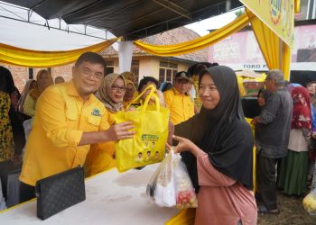 Ketua DPD II Partai Golkar Muaro Jambi, Ir. H. Ivan Wirata, ST, MM, MT, menyerahkan paket sembako murah kepada warga dalam kegiatan Pasar Murah HUT ke-61 Partai Golkar di Pasar Kedemangan, Minggu (19/10/2025). (Dok,. Stepanus)