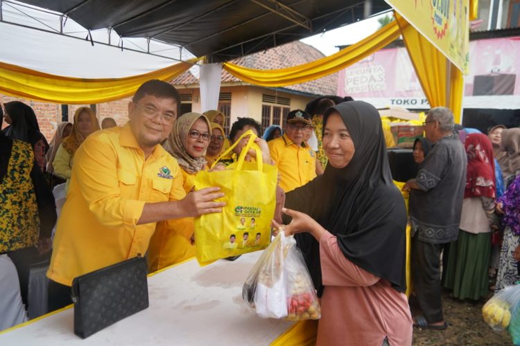 Ketua DPD II Partai Golkar Muaro Jambi, Ir. H. Ivan Wirata, ST, MM, MT, menyerahkan paket sembako murah kepada warga dalam kegiatan Pasar Murah HUT ke-61 Partai Golkar di Pasar Kedemangan, Minggu (19/10/2025). (Dok,. Stepanus)