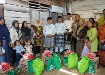 Gubernur Jambi Al Haris menyerahkan bantuan paket sembako dan susu kepada keluarga penerima manfaat program penurunan stunting di Kabupaten Bungo, Minggu (19/10/2025). (Dok. Erit - Kominfo)