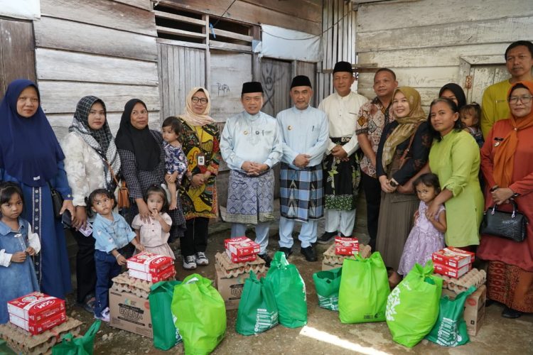 Gubernur Jambi Al Haris menyerahkan bantuan paket sembako dan susu kepada keluarga penerima manfaat program penurunan stunting di Kabupaten Bungo, Minggu (19/10/2025). (Dok. Erit - Kominfo)