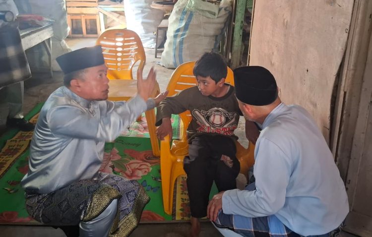 Gubernur Jambi Al Haris berbincang dengan Misba, seorang anak penyandang disabilitas di Kabupaten Bungo, usai menyerahkan kursi roda dan bantuan sembako, Minggu (19/10/2025). (Foto: Diskominfo - Erict Sutriedi)