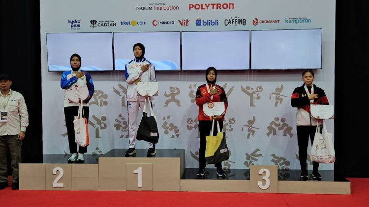 Pesilat Jambi Andhini Ayu Puspita Dewi (kedua dari kanan) berdiri di podium usai meraih medali perak kelas D putri pada ajang PON Bela Diri 2025 di GOR Djarum Kaliputu, Kudus, Jawa Tengah, Selasa (21/10/2025). (Dok. Koni Jambi)