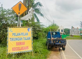 Petugas Satlantas Polresta Jambi memasang rambu peringatan di Jalan Lingkar Barat II, Kelurahan Simpang Rimbo, Kecamatan Alam Barajo, Kota Jambi, Rabu (22/10/2025). (Foto: Nahar)