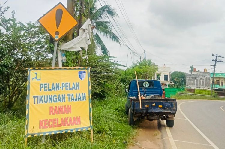Petugas Satlantas Polresta Jambi memasang rambu peringatan di Jalan Lingkar Barat II, Kelurahan Simpang Rimbo, Kecamatan Alam Barajo, Kota Jambi, Rabu (22/10/2025). (Foto: Nahar)