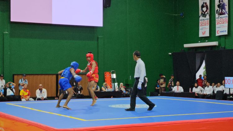 Atlet wushu Jambi (merah) menghadapi lawannya dalam nomor sanda pada PON Bela Diri 2025 di GOR Djarum, Kaliputu, Kudus, Jawa Tengah, Jumat (24/10/2025). (Sok.. Humas KONI Jambi)