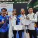 Manajer tim wushu Jambi Rio Setiadi (kiri) bersama atlet dan pelatih berpose menunjukkan medali yang diraih usai pertandingan cabang wushu pada PON Bela Diri 2025 di GOR Djarum Kaliputu, Kudus, Jawa Tengah, Minggu (26/10/2025). (Dok. Humas KONI)