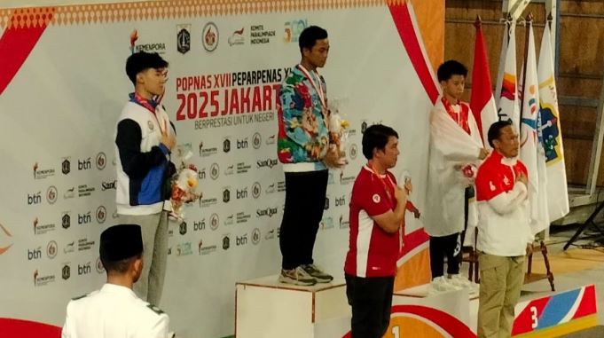 Atlet wushu asal Jambi, Carlson Ong (tengah), menerima medali perunggu pada ajang Pekan Olahraga Pelajar Nasional (POPNAS) XVII 2025 di Jakarta. (Dok. Humas POPNAS XVII 2025)
