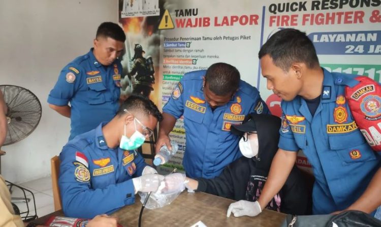 Petugas Dinas Pemadam Kebakaran dan Penyelamatan (Damkartan) Kota Jambi mengevakuasi cincin titanium yang terjebak di jari seorang warga menggunakan alat gerinda mini, Senin (24/11/2025). (Dok. Stepanus)