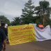 Warga membentangkan spanduk berisi tiga tuntutan saat menggelar aksi protes di depan kantor Pertamina EP Kenali Asam Bawah, Jambi, menolak penetapan zona merah yang dinilai merugikan pemilik tanah. Senin (24/11/2025), (Dok. Stepanus)