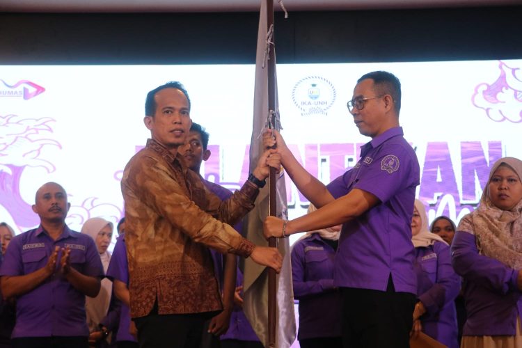 Asisten I Pemprov Jambi Arief Munandar menyerahkan bendera kepada Ketua IKA UNH Fiet Haryadi pada pelantikan pengurus IKA UNH di Rumah Dinas Gubernur Jambi, Kamis (27/11/2025).(dok.stepanus)