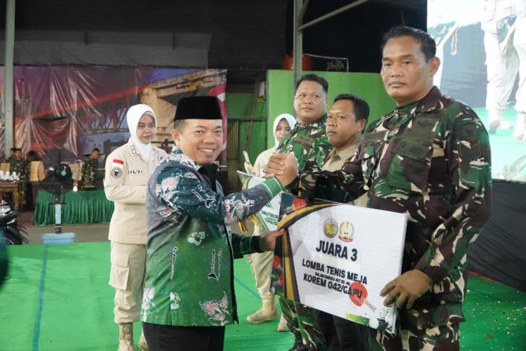 Gubernur Jambi Al Haris menyerahkan hadiah kepada perwakilan prajurit Korem 042/Garuda Putih pada peringatan HUT ke-66 Korem 042/Gapu di Lapangan Tenis Indoor Korem 042/Gapu, Sabtu (29/11/2025) malam. (Dok. Erit - Kominfo)