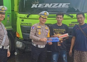 Kasatgas Preemtif Operasi Zebra Siginjai 2025 Kompol Dr. Novrizal menyerahkan perlengkapan segitiga pengaman kepada pengemudi truk saat pemeriksaan keselamatan di Terminal Barang Talang Gulo, Kota Jambi, Jumat (21/11/2025).(Dok.Nahar)