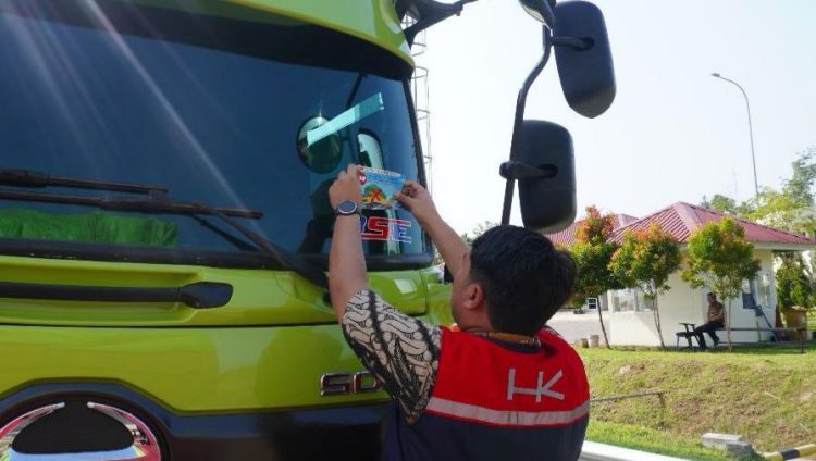 Petugas Hutama Karya menempelkan stiker imbauan keselamatan “Zero ODOL” di kaca depan kendaraan angkutan barang dalam kegiatan sosialisasi di salah satu ruas tol. (Dok. HK)
