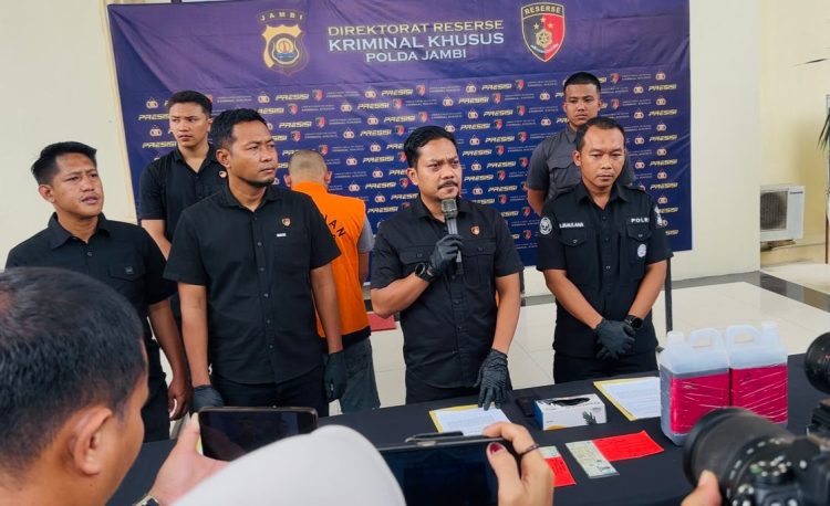 Personel Ditreskrimsus Polda Jambi menunjukkan barang bukti berupa dokumen dan jeriken berisi solar olahan hasil pengungkapan kasus pengangkutan BBM ilegal lintas provinsi, Selasa (4/11/2025). (Dok. Nahar)