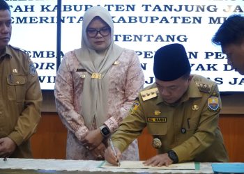 Gubernur Jambi Al Haris menandatangani komitmen bersama percepatan realisasi Participating Interest (PI) 10 persen Wilayah Kerja Migas Lemang dan Jabung, disaksikan Bupati Tanjung Jabung Timur Dillah Hikmah Sari dan pejabat terkait di Rumah Dinas Gubernur Jambi, Selasa (4/11/2025). (Dok. ERit- Kominfo)