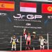 Pebalap muda Indonesia M. Kiandra Ramadhipa mengibarkan bendera Merah Putih di podium tertinggi usai menjuarai European Talent Cup (ETC) FIM JuniorGP 2025 di Circuit de Barcelona-Catalunya, Spanyol, Minggu (2/11/2025). (Dok. Sisnsen)
