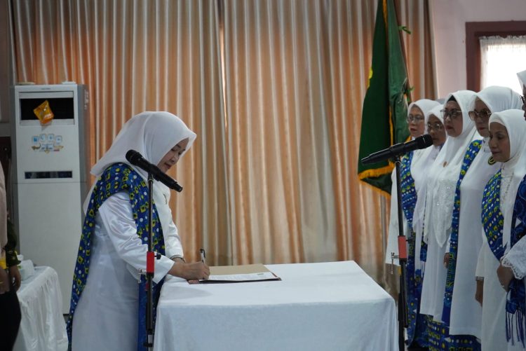 Ketua TP-PKK Provinsi Jambi sekaligus Ketua PW BKMT Provinsi Jambi, Hj. Hesnidar Haris (Hesti Haris), menandatangani berita acara pelantikan Pengurus Daerah BKMT Kabupaten Bungo periode 2025–2029 di Wisma PP Alisudin, Rumah Dinas Bupati Bungo, Kamis (6/11/2025). (Dok. Erit - Kominfo)