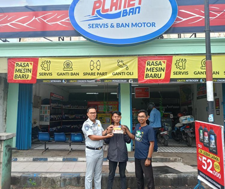 Petugas Jasa Raharja menyerahkan voucher apresiasi kepada wajib pajak di salah satu outlet Planet Ban, sebagai bentuk kerja sama program penghargaan bagi pembayar pajak kendaraan bermotor yang taat, Jumat (6/11/2025). (Dok. Humas JR)