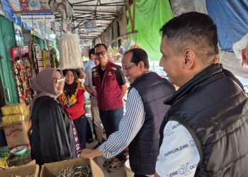 Petugas Polresta Jambi bersama Badan Pangan Nasional dan Dinas Pangan Kota Jambi saat melakukan pengecekan harga serta stok beras di Pasar Talang Banjar, Jumat (14/11/2025). (Dok. Nahar)