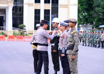 Kapolda Jambi menyematkan tanda operasi kepada personel saat Apel Gelar Pasukan Operasi Zebra 2025 di Lapangan Hitam Mapolda Jambi, Senin (17/11/2025). (Dok. Nahar)