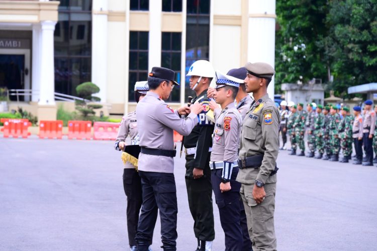 Kapolda Jambi menyematkan tanda operasi kepada personel saat Apel Gelar Pasukan Operasi Zebra 2025 di Lapangan Hitam Mapolda Jambi, Senin (17/11/2025). (Dok. Nahar)