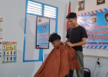Seorang instruktur memberikan pelatihan teknik memangkas rambut kepada remaja Pulau Pandan dalam kegiatan pembinaan masyarakat di Rumah Baca Bhayangkara Bahari, Rabu (20/11/2025). (Dok,. Nahar)