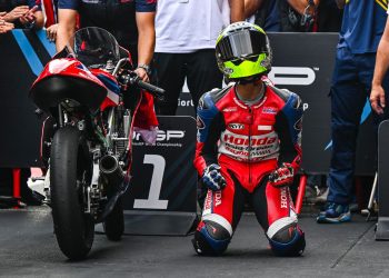 Seorang pebalap muda berlutut di samping motornya seusai merampungkan sesi balap, menggambarkan momen emosional di arena kompetisi. (Dok. Sinsen)