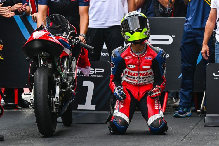 Seorang pebalap muda berlutut di samping motornya seusai merampungkan sesi balap, menggambarkan momen emosional di arena kompetisi. (Dok. Sinsen)