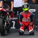 Seorang pebalap muda berlutut di samping motornya seusai merampungkan sesi balap, menggambarkan momen emosional di arena kompetisi. (Dok. Sinsen)