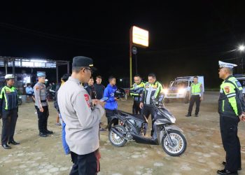 Petugas Polres Tanjung Jabung Timur memeriksa kendaraan dan memberikan imbauan kepada remaja saat patroli antisipasi balap liar dalam Operasi Zebra Siginjai 2025, Minggu (22/11/2025) malam. (Dok. Nahar)